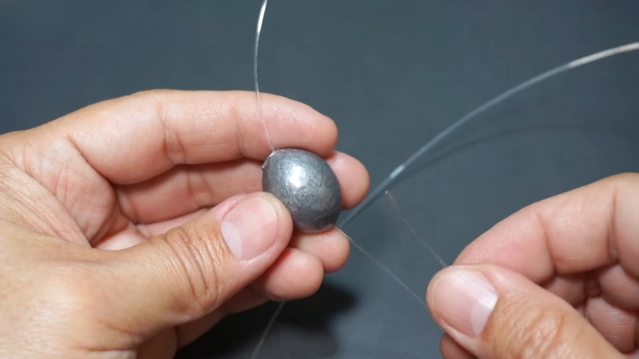 Man Demonstrating how To Put Sinkers on A Fishing Line