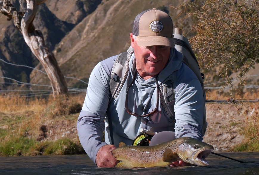 Fisherman holding a freshly caught brown trout