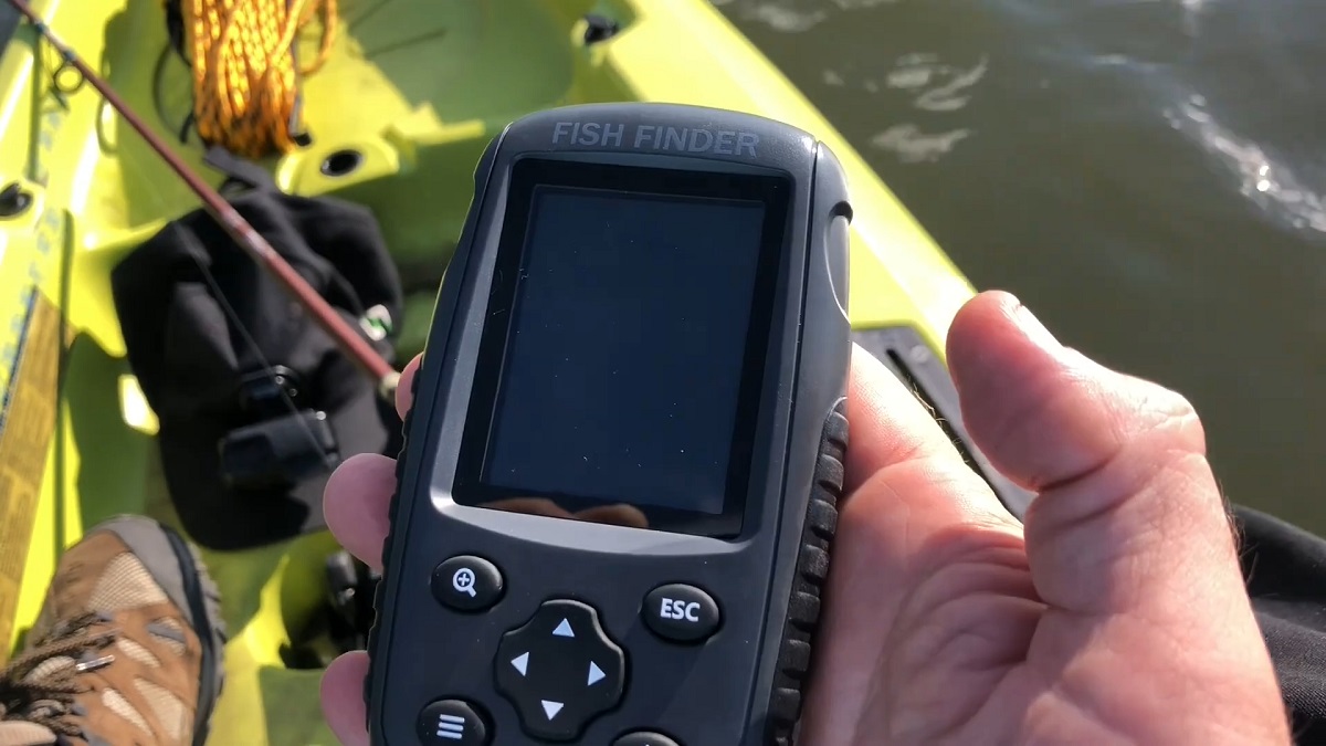 A person holding a Venterior portable fish finder while fishing on a kayak