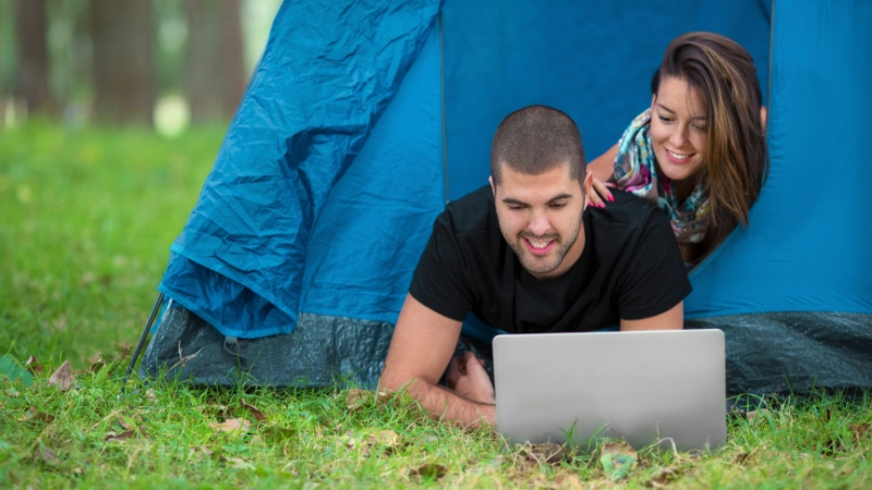 A man and woman inside a tent working on a laptop, showing early steps in building a strong outdoor brand