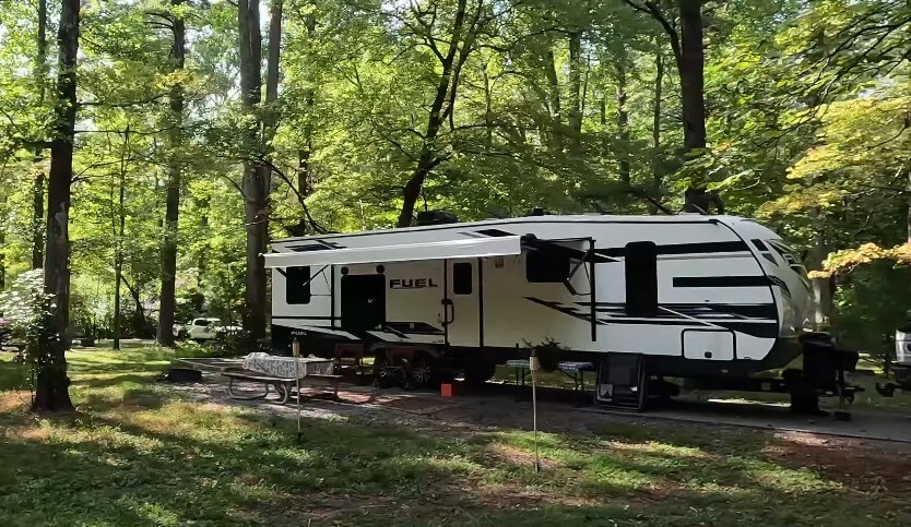 Camping spot featuring a motorhome, picnic table, and hammock