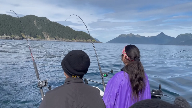 Two friends on a boat enjoy fishing trips with rods in hand